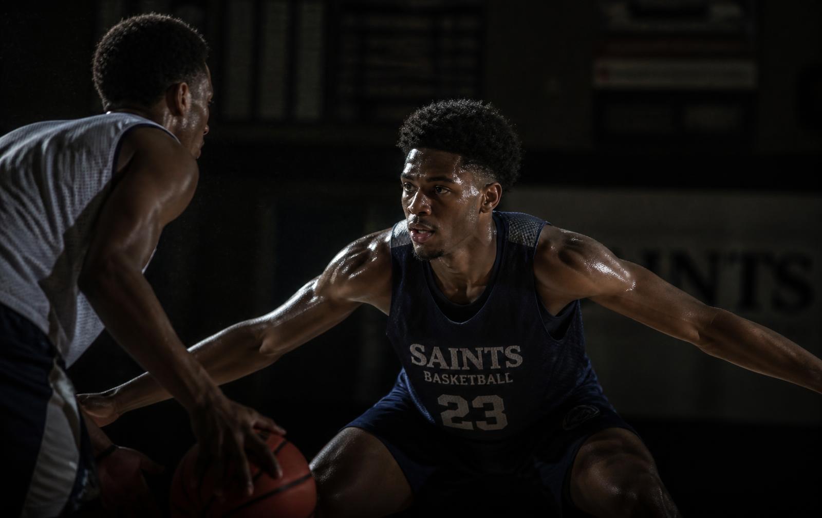 Basketball players competing hard during a dark gym practice